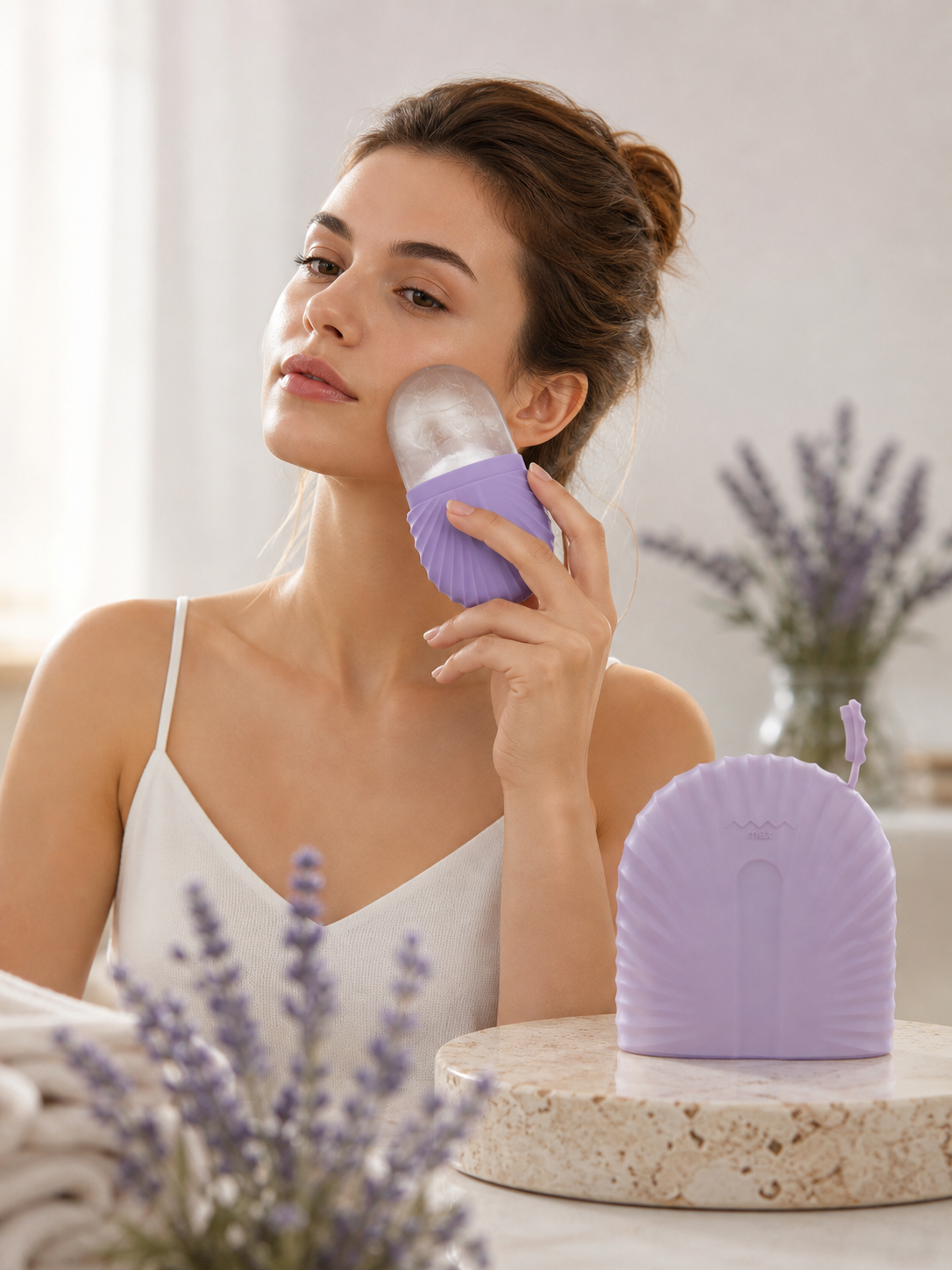 Mujer usando el molde de hielo facial de silicona morado sobre la mejilla