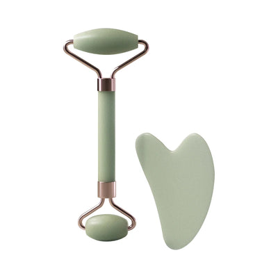 Set rodillo facial y gua sha verde sobre fondo blanco